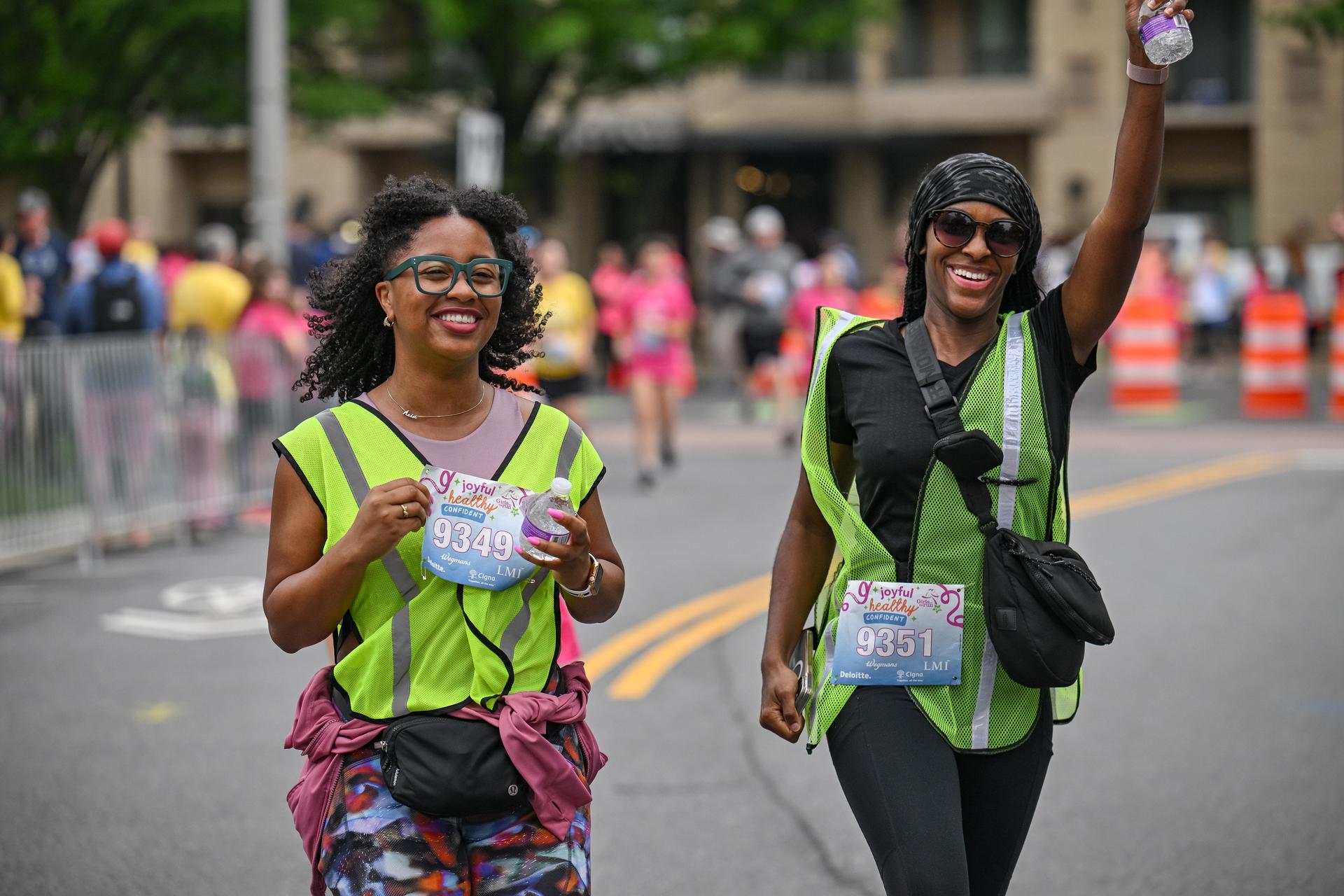 Two adult 5K participants smiling as they near the finish line.