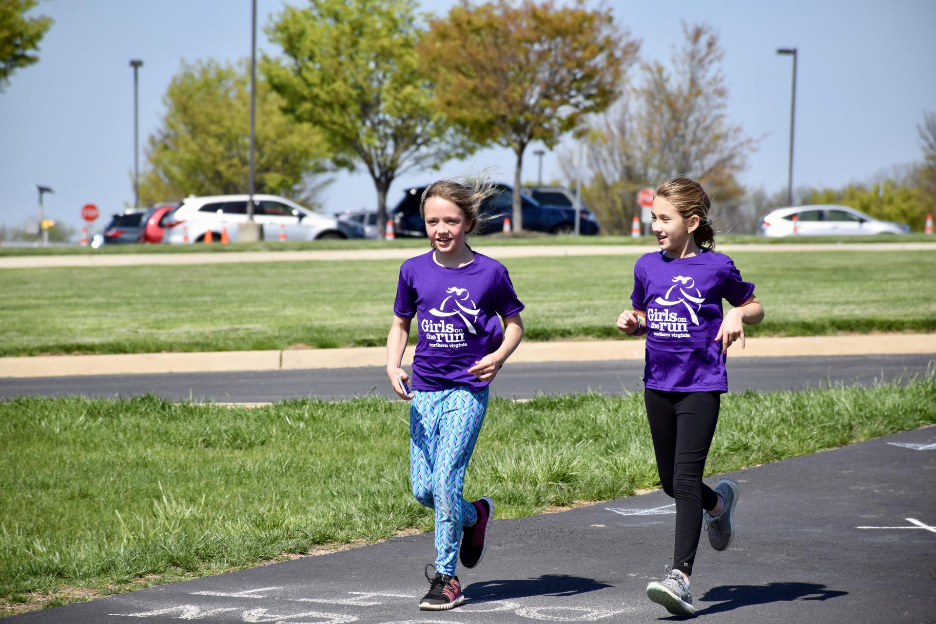 Two girls on the run participants running at practice.