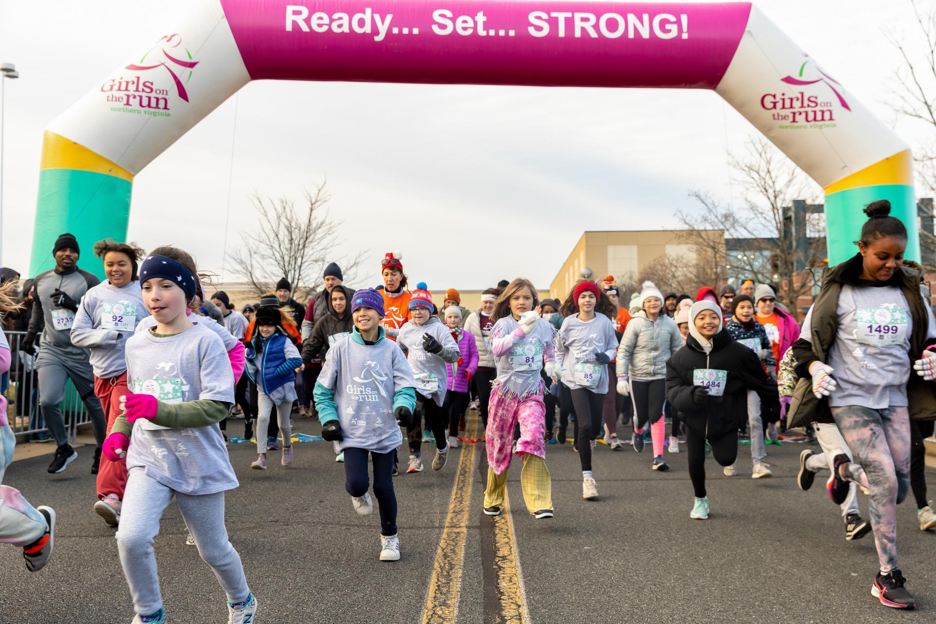 Girls on the Run participants crossing the start line of the 5K.