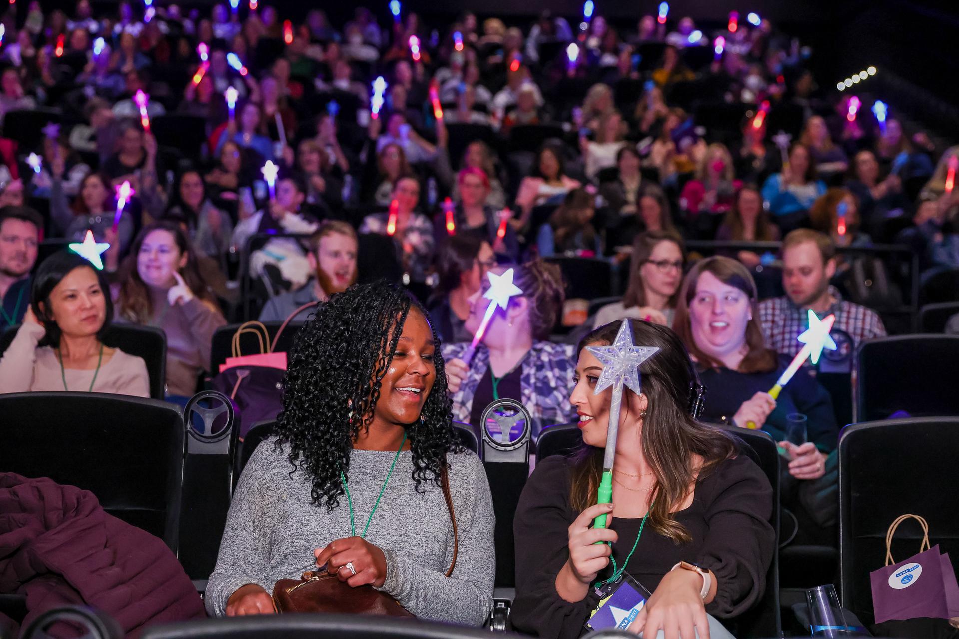 LUNAFEST attendees sitting in the theatre with light-up star wands.