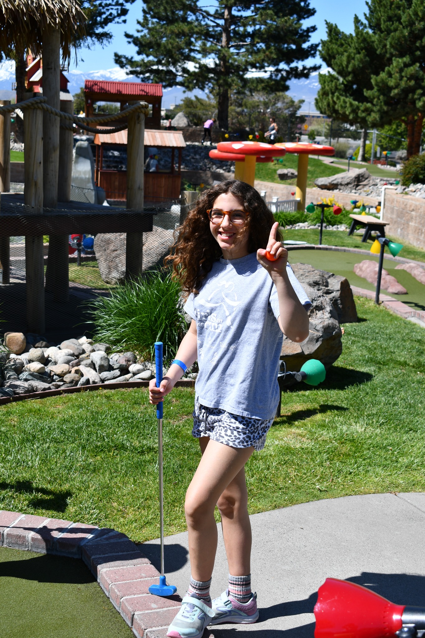 Girls on the Run participant posing for a photo in a Girls on the Run t-shirt while holding a mini golf club.